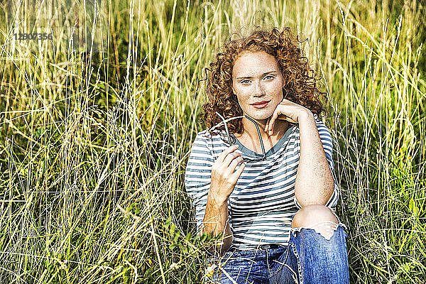 Young of woman sitting on a meadow