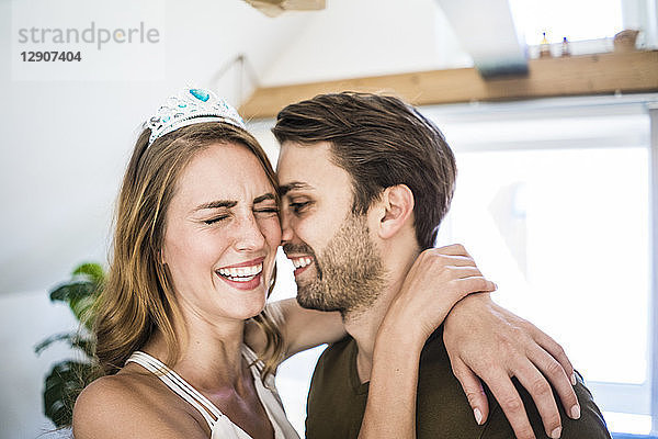 Happy couple at home with woman wearing tiara