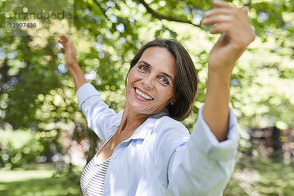 Portrait of smiling mature woman dancing in nature