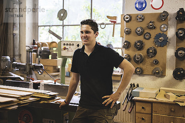 Smiling carpenter standing in his workshop