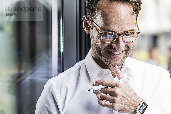 Portrait of laughing businessman wearing glasses and smartwatch