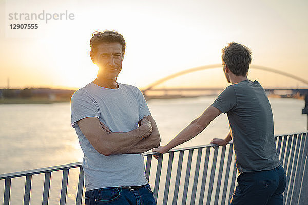 Two friends watching sunset at the river