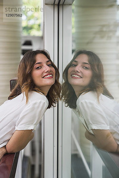 Young woman posing in front of glass screen
