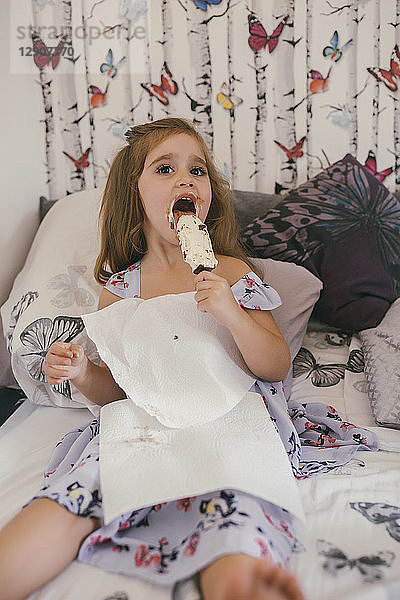 Little girl eating giant ice cream in her room