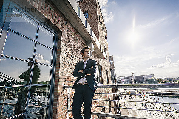 Pensive businessman standing on balcony