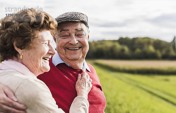 Happy senior couple embracing in rural landscape