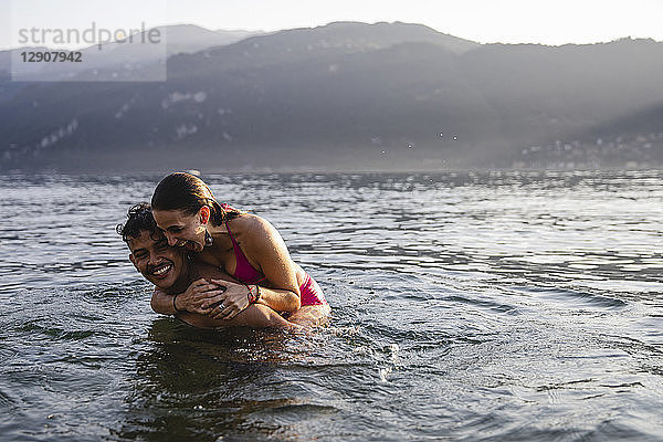 Happy playful young couple in a lake