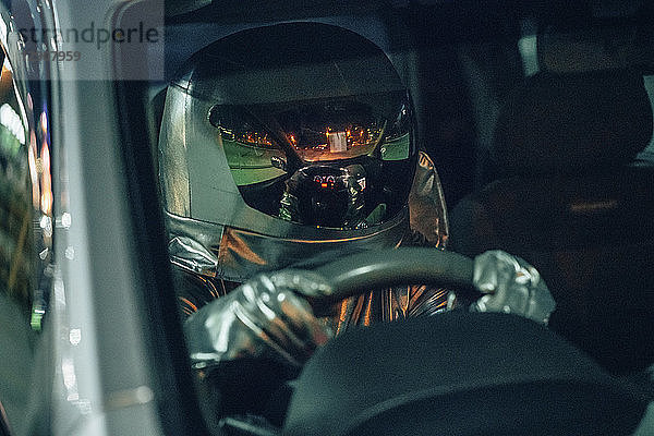 Spaceman driving car at night