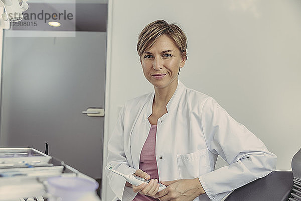 Female dentist holding electrical tooth brush