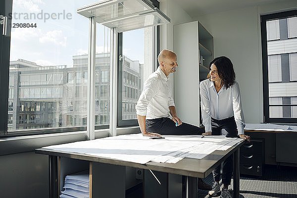 Two architects working in office  discussing blueprints