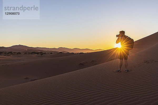 Africa  Namibia  Namib desert  Naukluft National Park  photographer on dune during sunrise