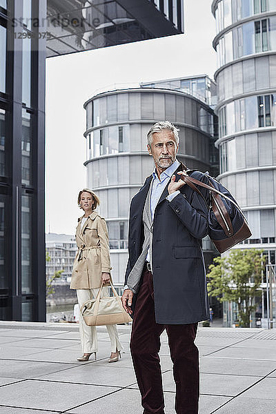 Germany  Duesseldorf  two fashionable business people with traveling bags