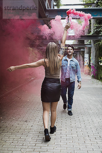Young couple with smoke torch outdoors
