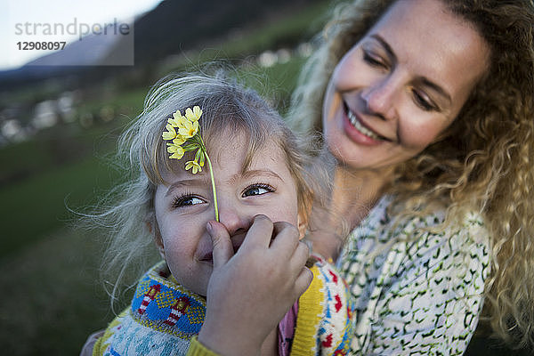 Happy mother and daughter with flowers on a meadow