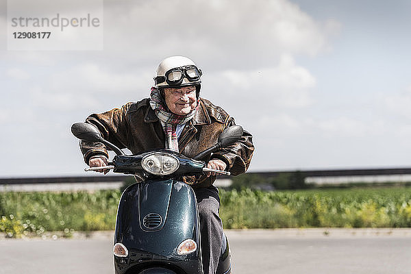 Active senior man speeding on his motor scooter