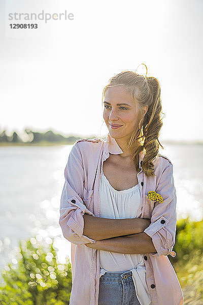 Portrait of smiling woman standing at the riverside in summer
