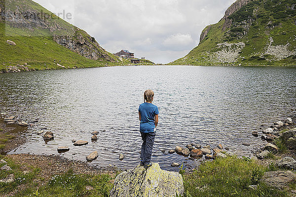 Austria  Tyrol  Fieberbrunn  Wildseeloder  girl standing at the shore of lake Wildsee