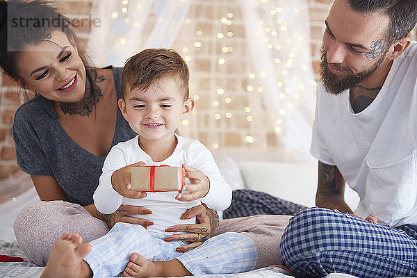 Happy family celebrating Christmas in bed