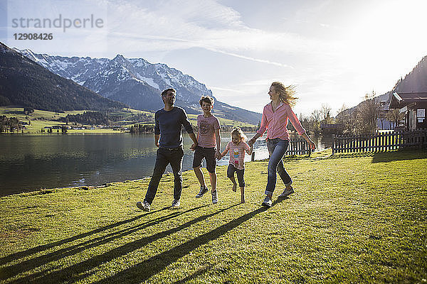 Austria  Tyrol  Walchsee  happy family walking at the lakeside
