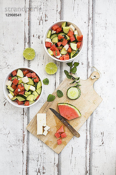 Watermelon salad with feta  cucumber  mint and lime dressing on white wood
