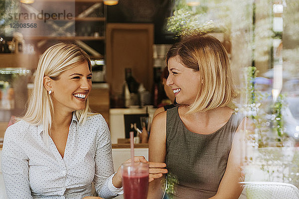Two happy young women in a cafe