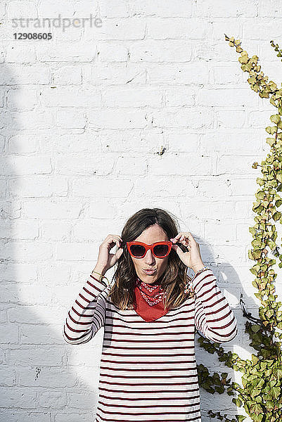 Portrait of fashionable woman wearing red sunglasses