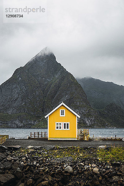 Norway  Lofoten  remote yellow house at rocky coast