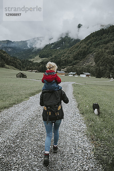 Austria  Vorarlberg  Mellau  mother carrying toddler on shoulders on a trip in the mountains