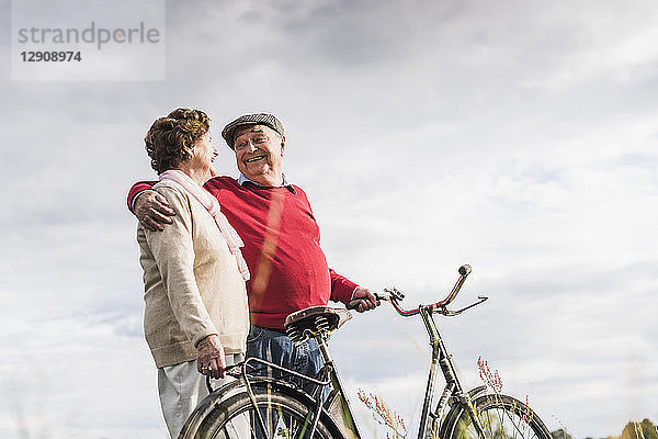 Happy senior couple with bicycles embracing