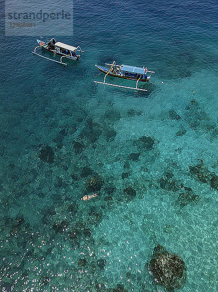Indonesia  Bali  Aerial view of Blue Lagoon  snorkeler and banca boats