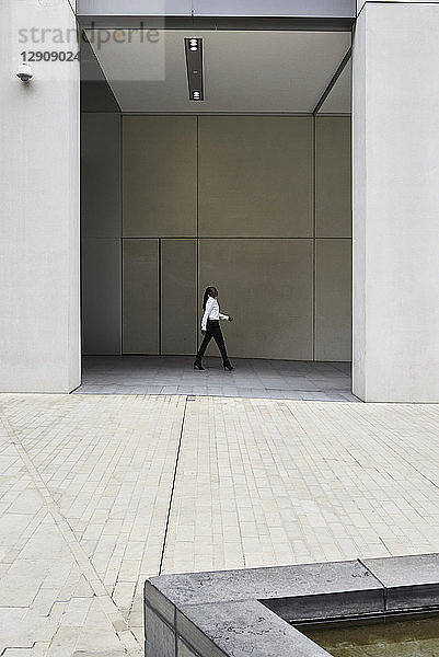 Businesswoman walking in front of a modern office building