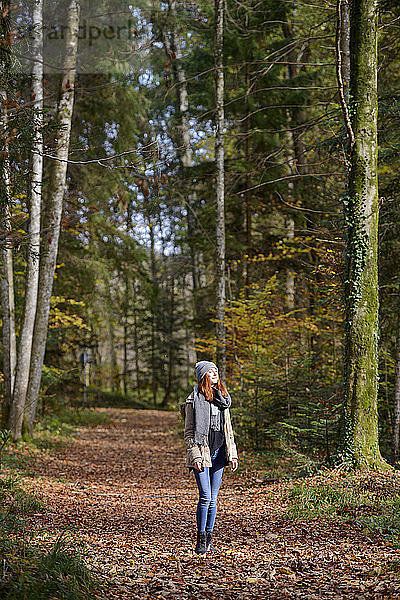 Redheaded teenage girl enjoying autumnal forest