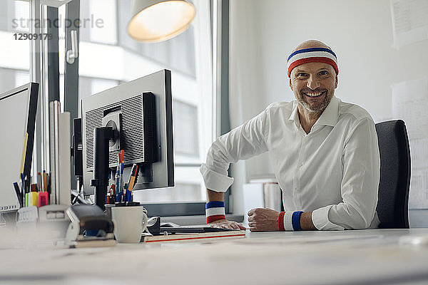 Businessman sitting in office  wearing sweat bands