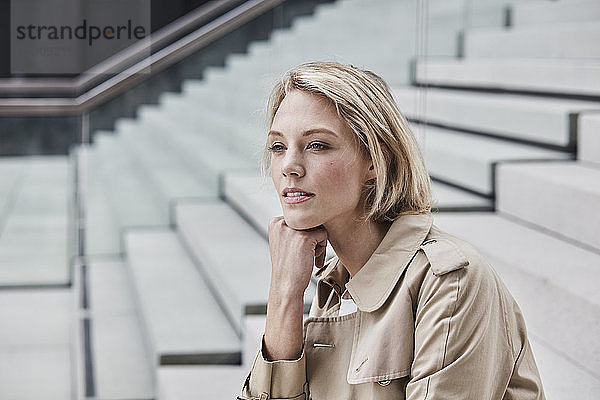 Portrait of blond businesswoman on stairs