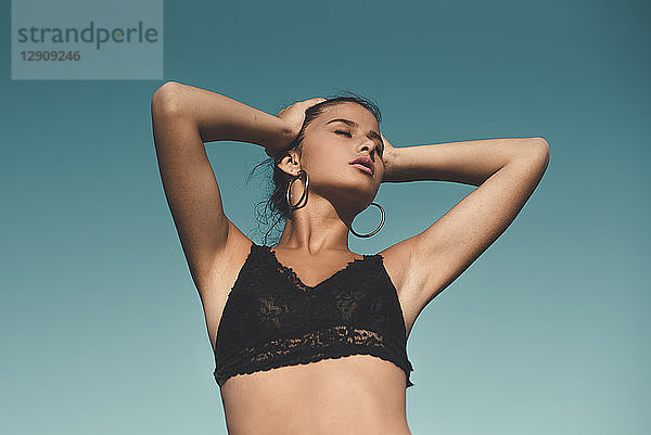 Portrait of teenage girl wearing black top against sky