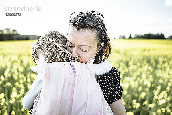 Little girl on her mother's arms in rape field
