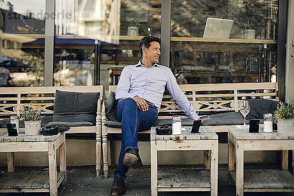 Businessman sitting in coffee shop  smiling