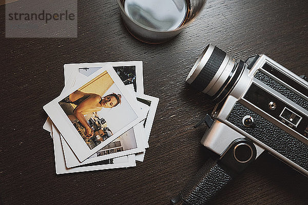 Stack of instant photos of young woman next to camera