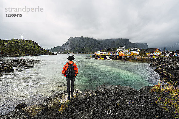 Norway  Lofoten  rear view of man standing at the coast