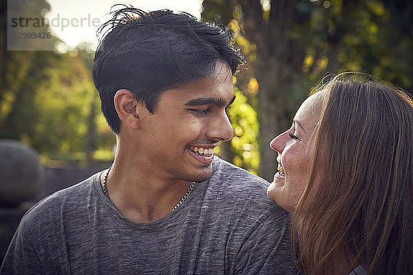 Happy young couple flirting in a park in summer