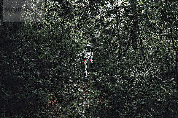 Spaceman exploring nature  looking at plants in forest