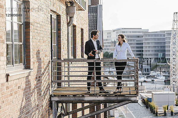 Business people standing on balcony  discussing