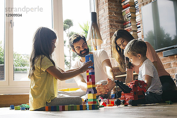 Family playing with building blocks on the floor together