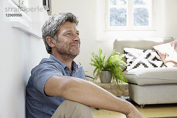 Mature man at home sitting in front of couch