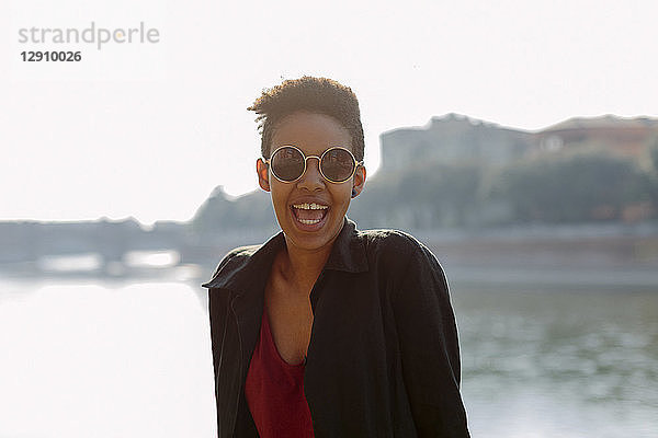 Italy  Verona  portrait of laughing young woman wearing sunglasses
