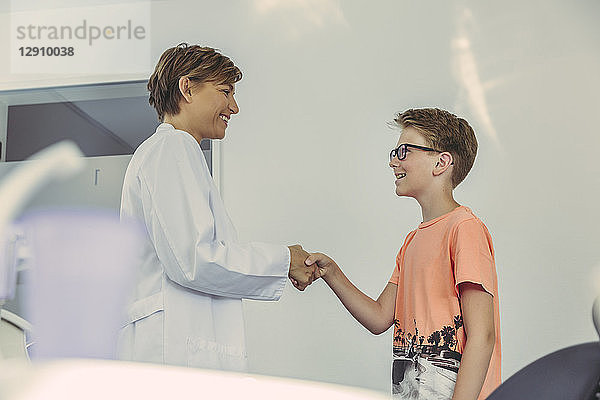 Boy greeting dentist  shaking hands
