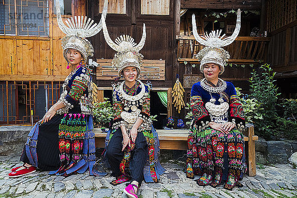 China  Guizhou  three Miao women wearing traditional dresses and headdresses