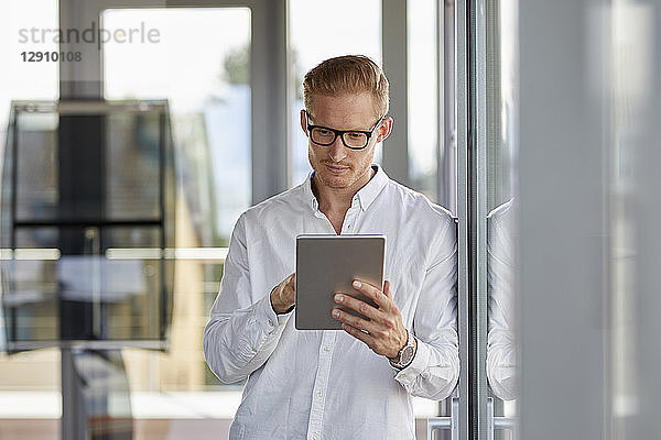 Businessman using tablet at the window in office