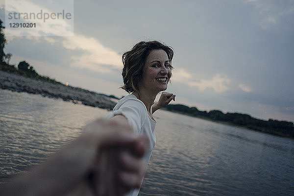 Laughing woman holding hands at the river