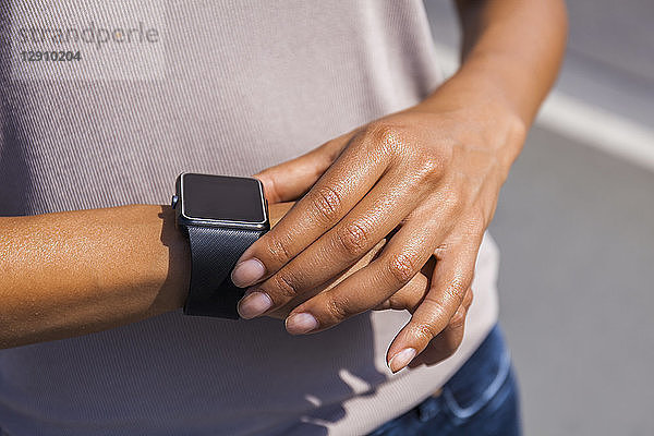 Woman's hand adjusting settings of smartwatch  close-up